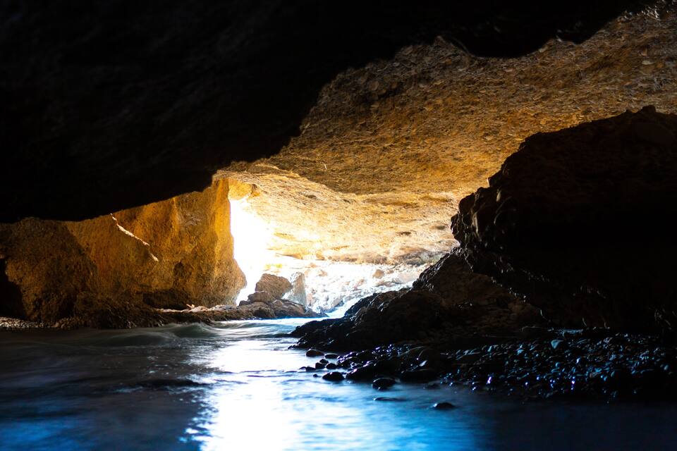 A cave with a stream flowing through it.