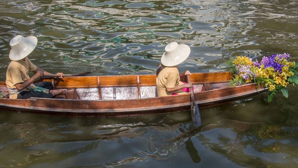 man paddling in the floating market in Thailand