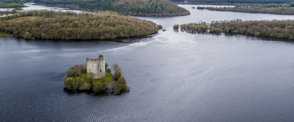 A large body of water with a small island featuring a historic tower.