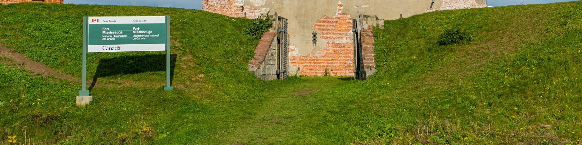 A brick fort with a sign in front.