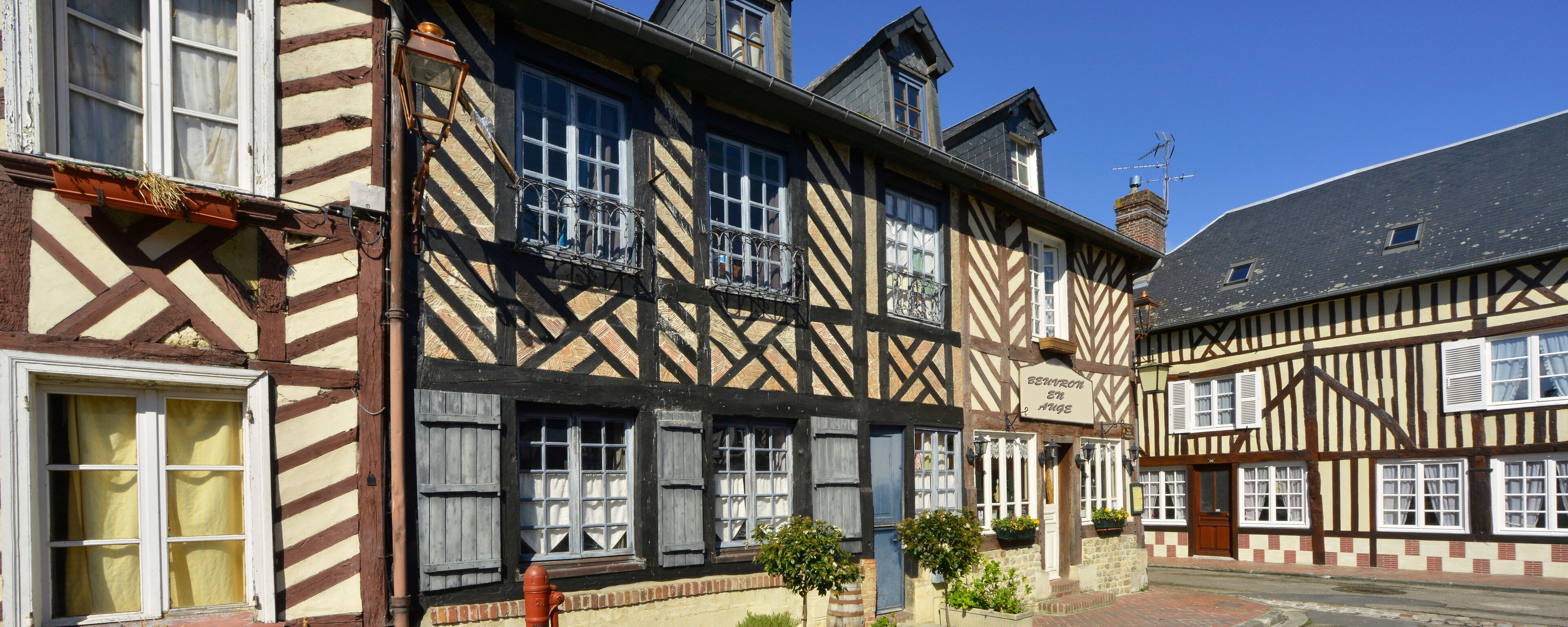 A traditional half-timbered building with a sign reading "Biergarten en Angu".