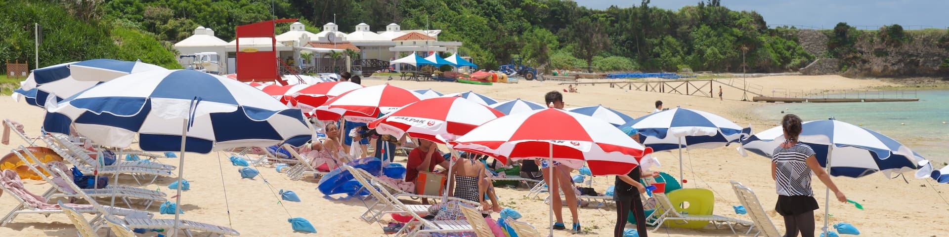 Nirai Beach showing a beach as well as a large group of people