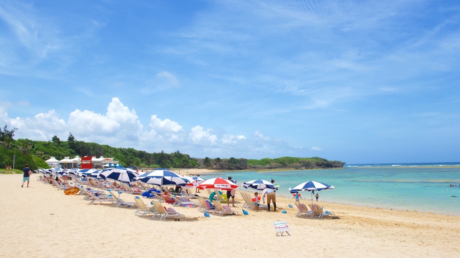 Nirai Beach which includes general coastal views and a sandy beach as well as a large group of people