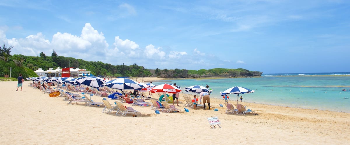 Nirai Beach which includes general coastal views and a sandy beach as well as a large group of people
