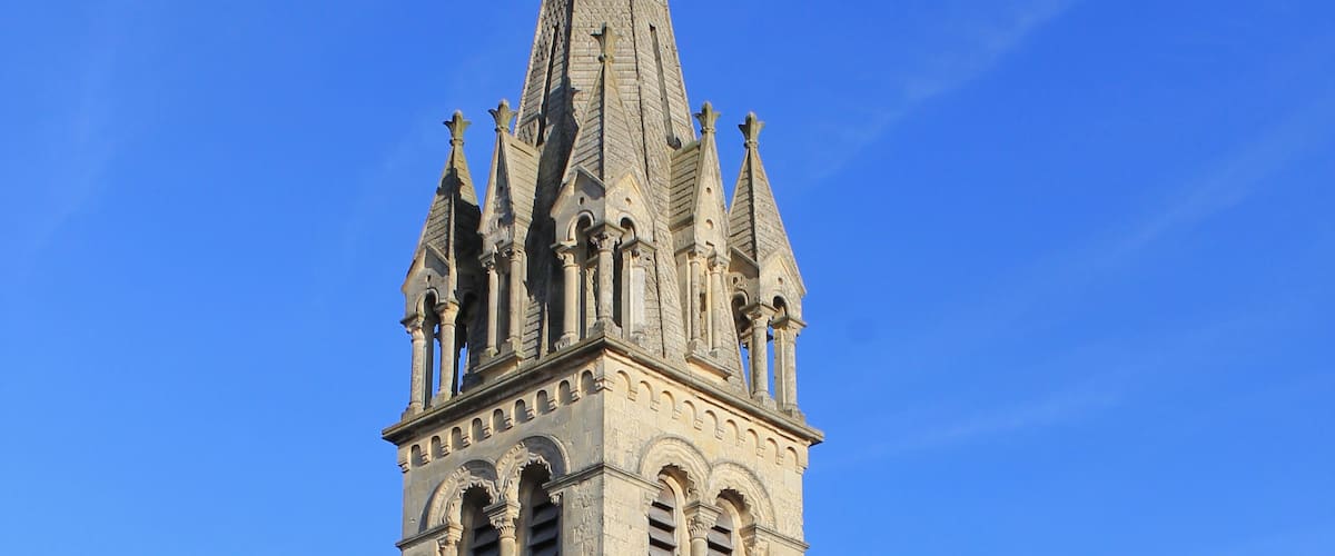 A church with a tall spire and arched windows.