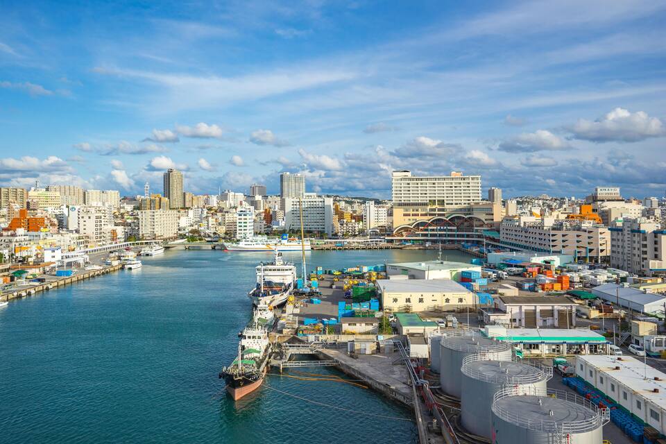 A coastal cityscape with a harbor, industrial buildings, and a mix of residential and commercial structures.