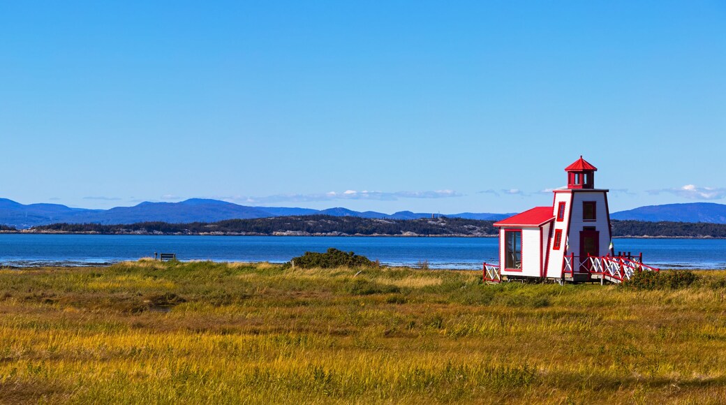 Small red and white lighthouse along the Saint Lawrence River; Saint Andre de Kamourraska, Quebec, Canada