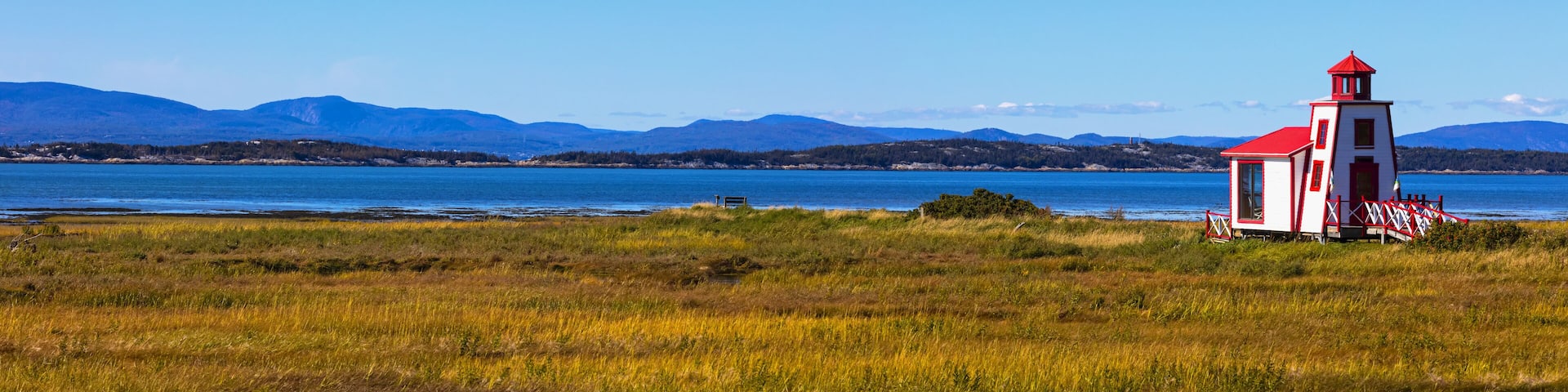 Small red and white lighthouse along the Saint Lawrence River; Saint Andre de Kamourraska, Quebec, Canada