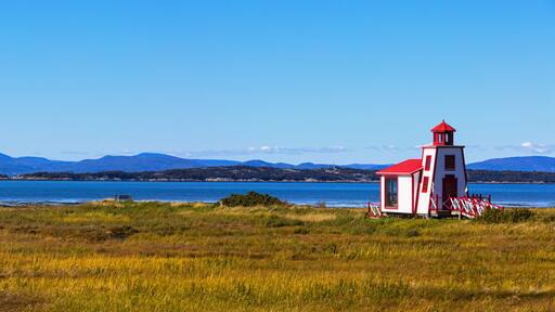 Small red and white lighthouse along the Saint Lawrence River; Saint Andre de Kamourraska, Quebec, Canada
