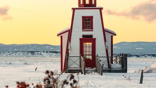 Winter's view of the little lighthouse of Saint-Andre-de-Kamouraska with ice on Saint-Lawrence river and the Charlevoix in background (Quebec, Canada).