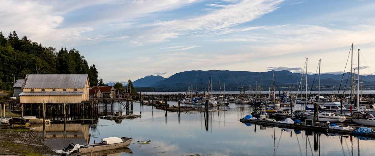 A harbor with boats, a wooden dock, and a building.