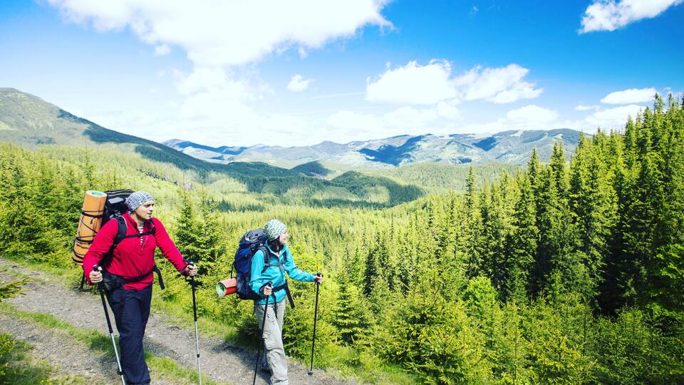 Summer hike in the mountains with a backpack and tent.