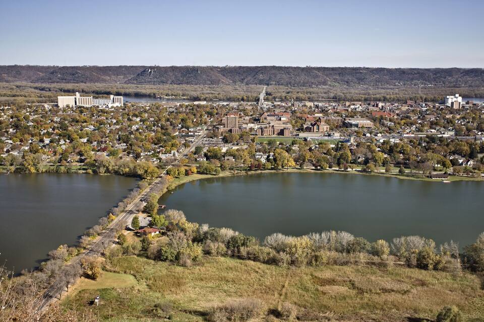 A town with a large lake, surrounded by hills and trees.