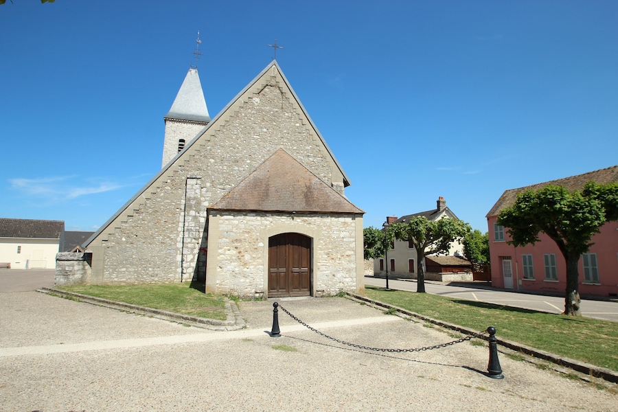 A stone church with a bell tower and a wooden door.