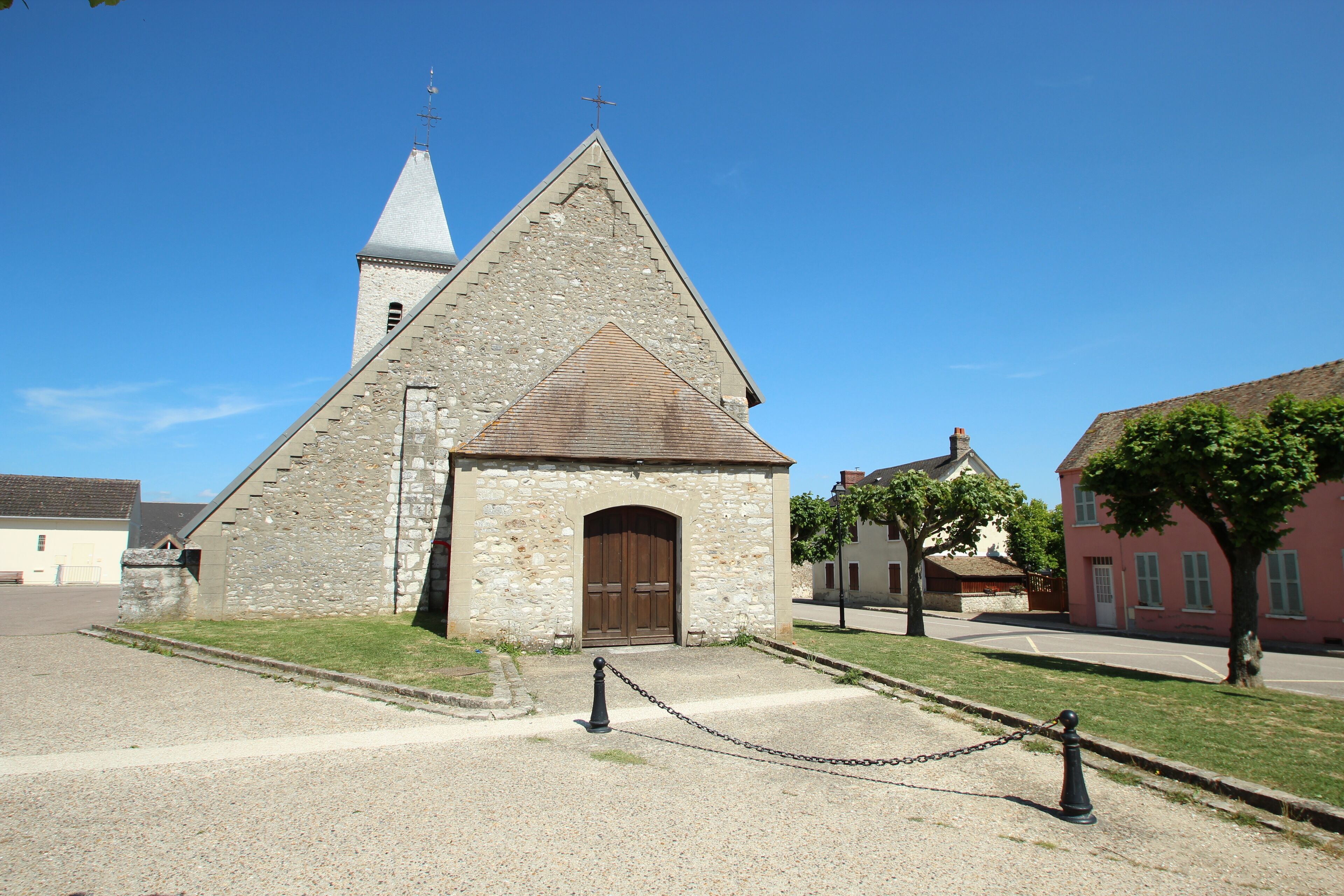 A stone church with a bell tower and a wooden door.