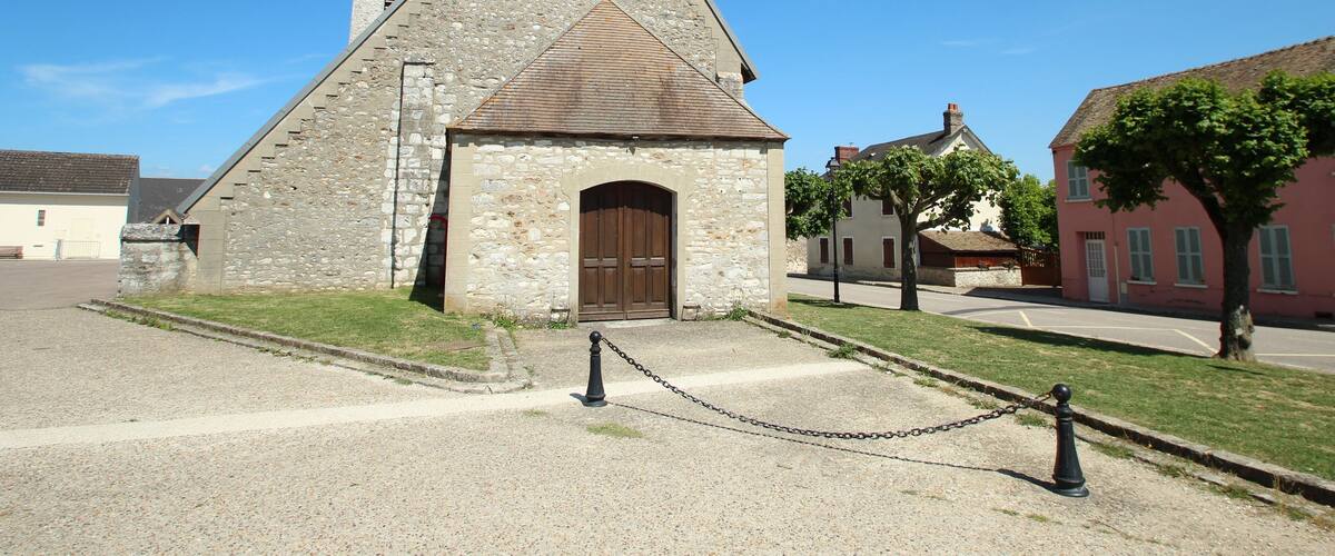 A stone church with a bell tower and a wooden door.