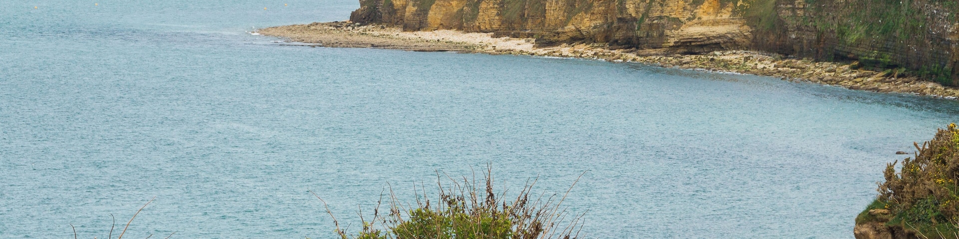 Un paisaje costero con acantilados y mar azul cristalino.