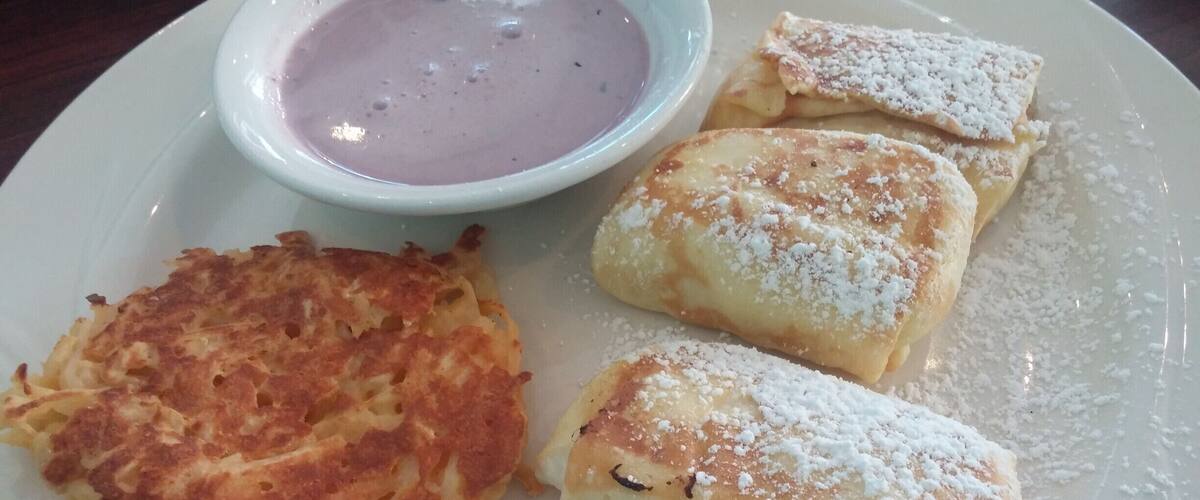 Cheese Blintzes - Grilled crepes with cottage and ricotta cheeses, flavored with orange zest and served with homemade blueberry sour cream sauce and a side of cheesy potato casserole from the Broken Egg in Sarasota.