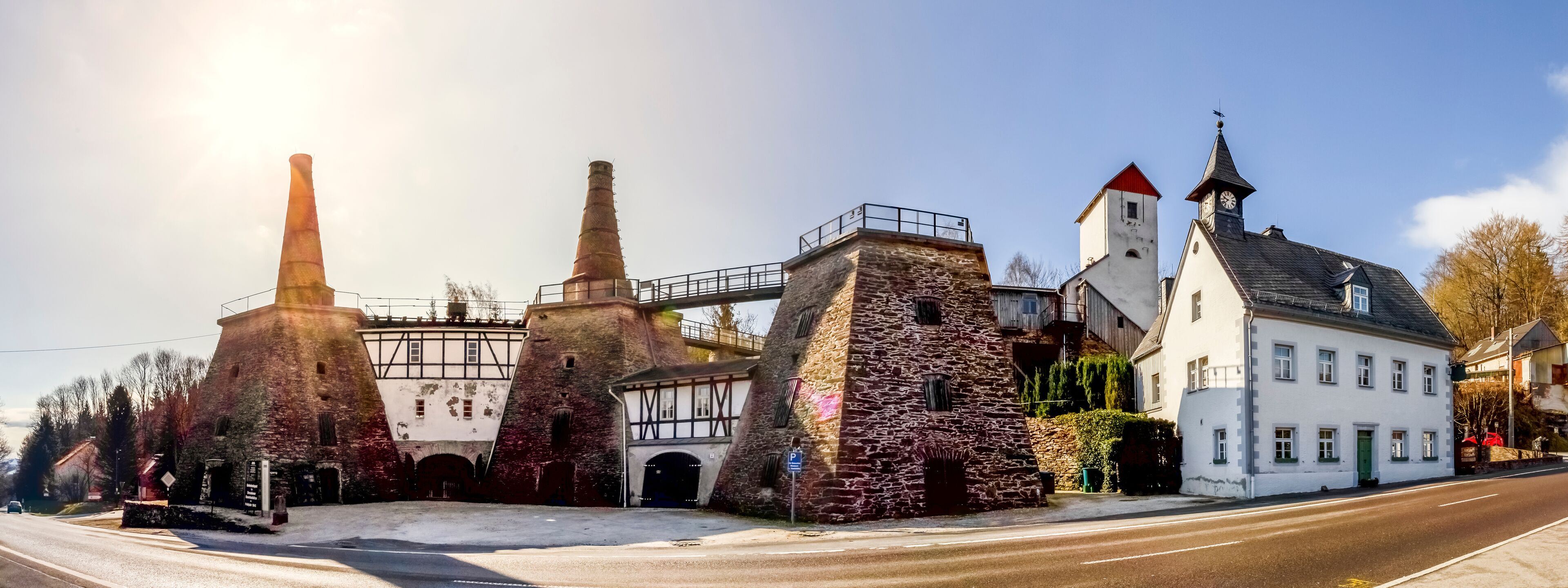 A historic building with stone towers and a white facade, a bridge, and a clock tower.