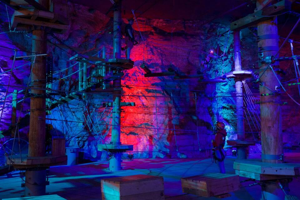 An indoor rock climbing area with wooden structures and ropes.