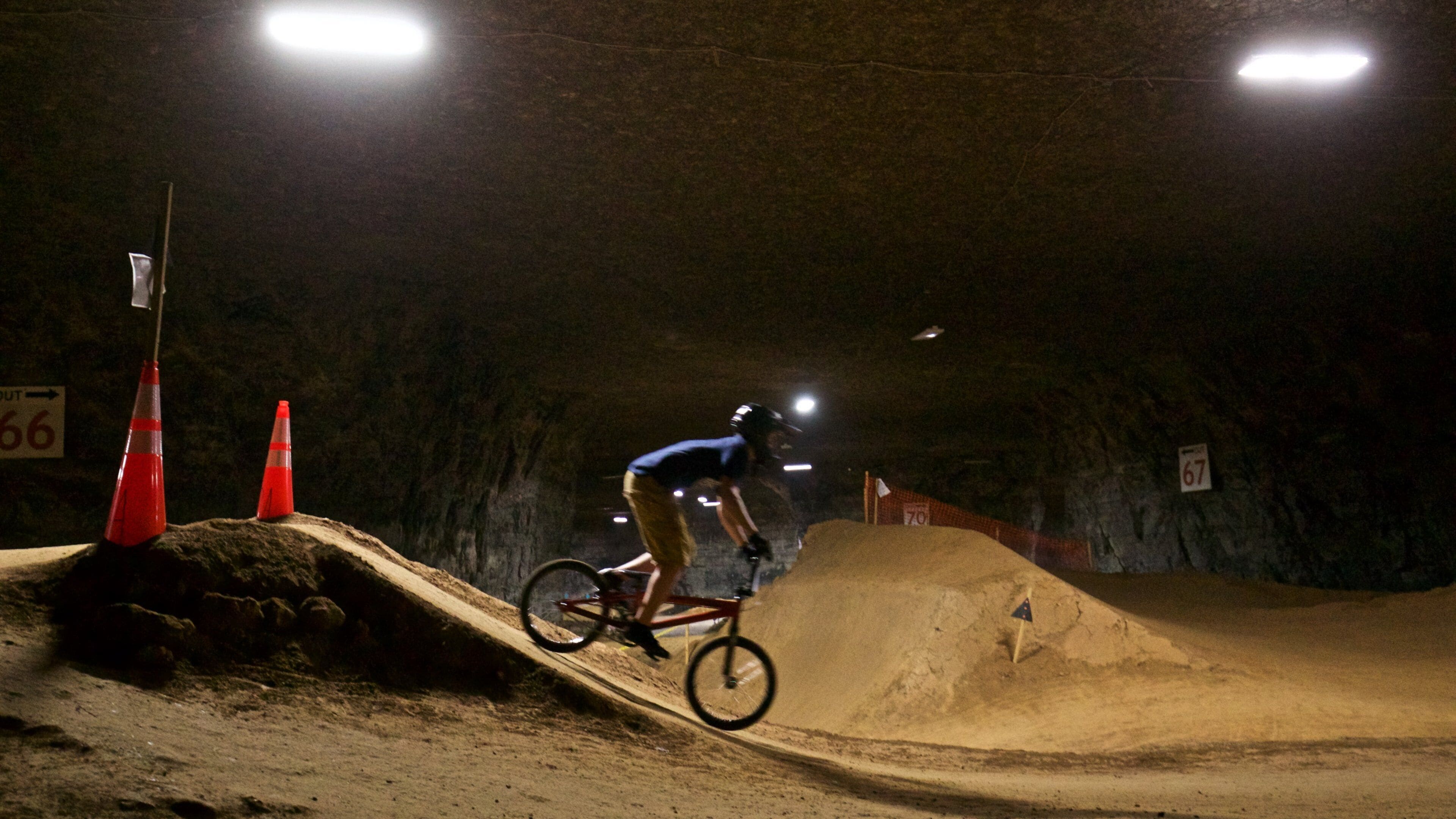 Louisville Mega Cavern which includes night scenes, a sporting event and mountain biking