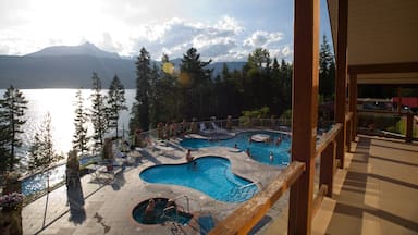 A pool area with multiple pools and a view of a lake and mountains.