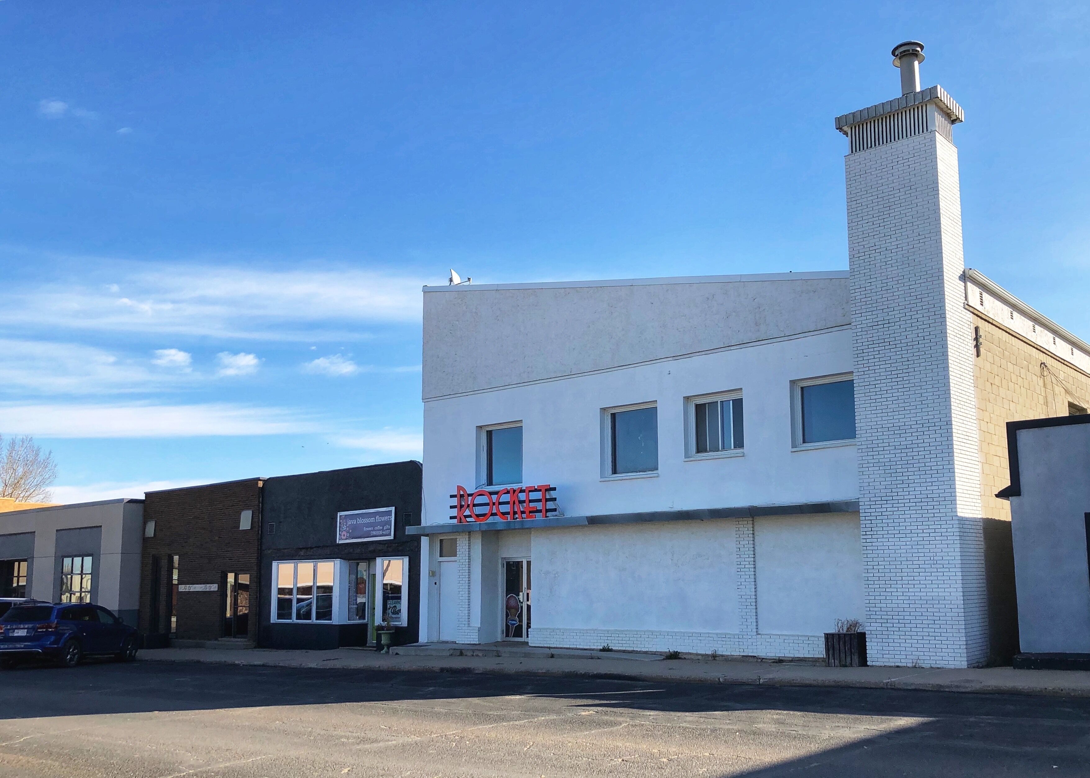 A white building with a red sign that reads "ROCKETS" and a chimney.