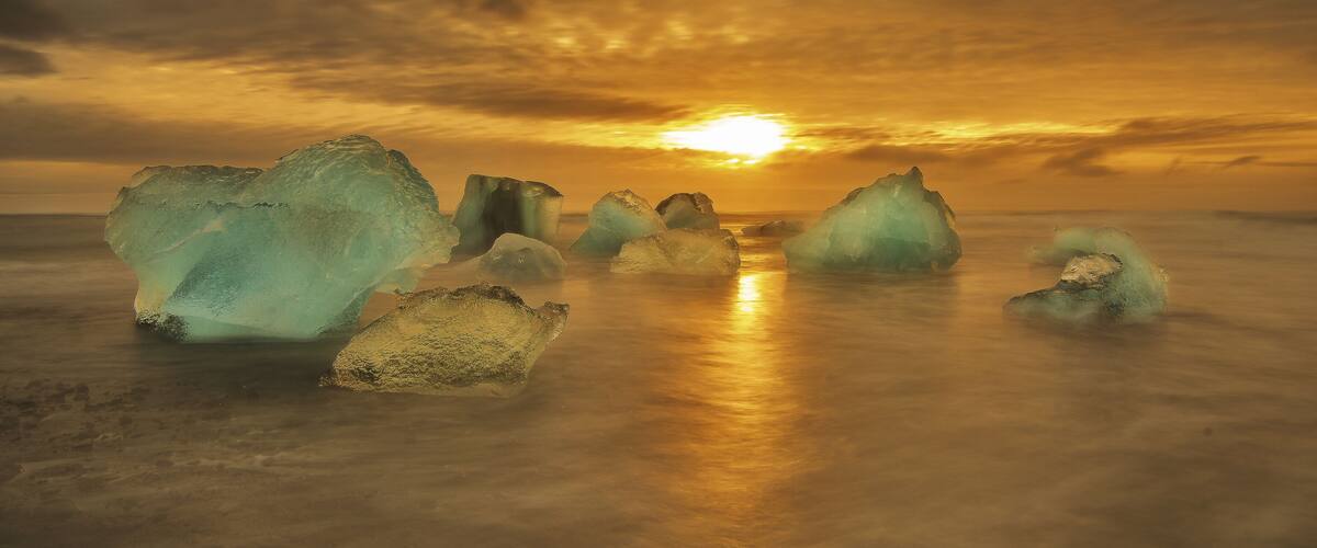 Icebergs in the ocean during sunset.
