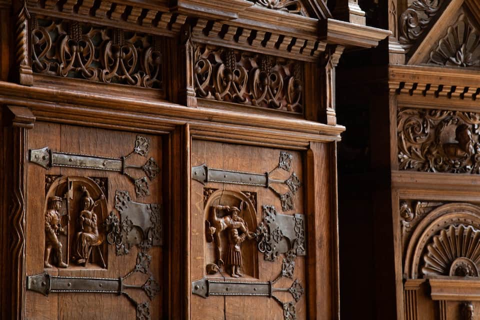 Aufwendig geschnitzte Holztüren mit religiösen Figuren und detailreichen Verzierungen.