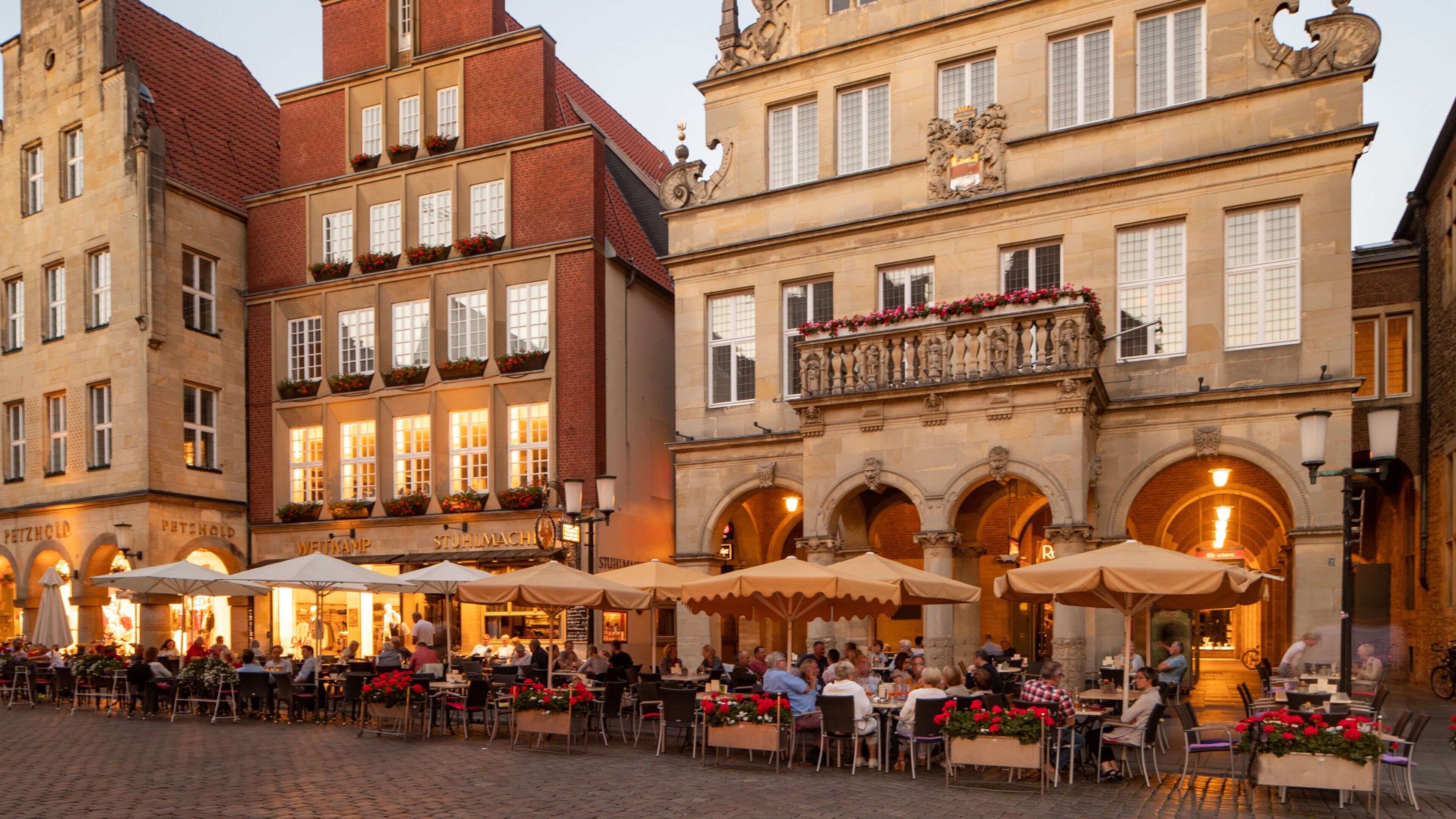 Prinzipalmarkt showing outdoor eating and a city as well as a small group of people