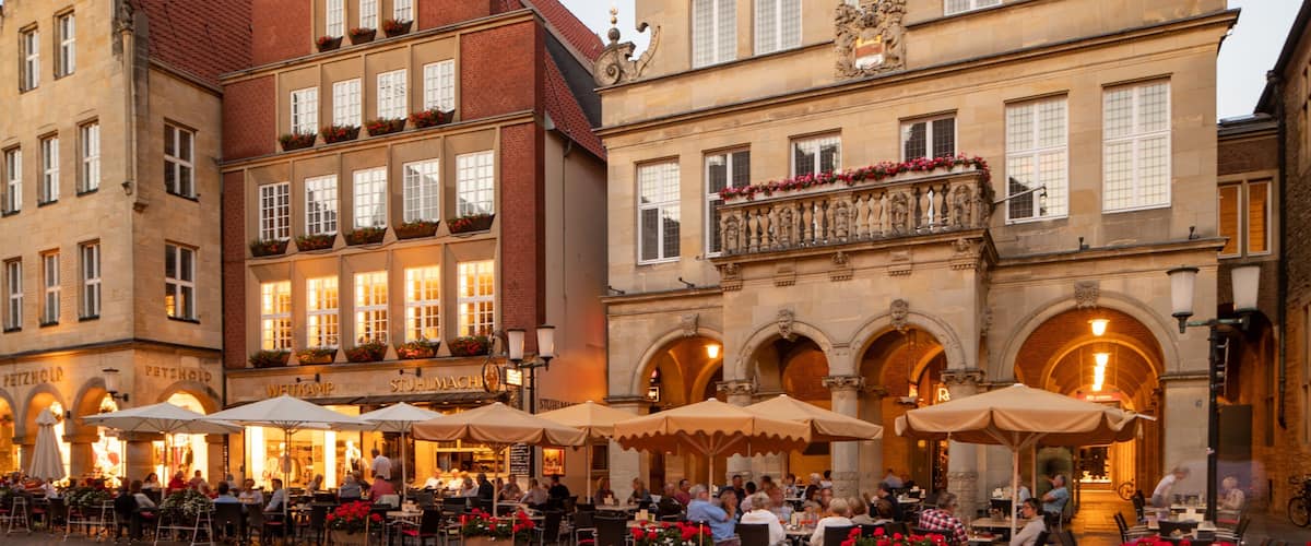 Prinzipalmarkt showing outdoor eating and a city as well as a small group of people