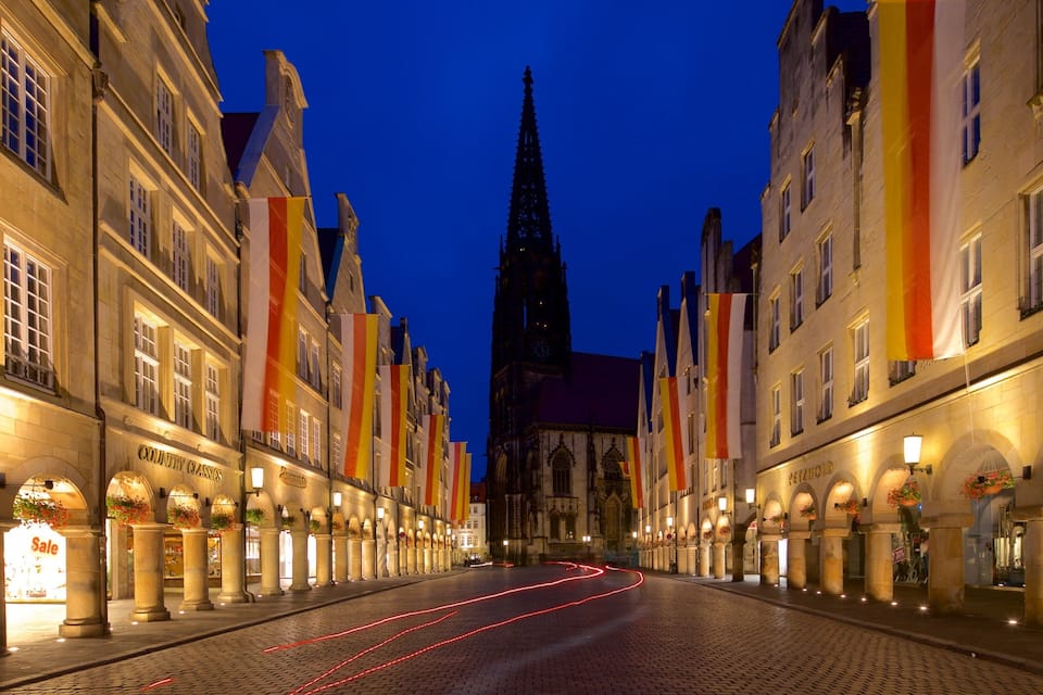 Eine Kopfsteinpflasterstraße gesäumt von historischen Gebäuden und einem markanten Kirchturm.