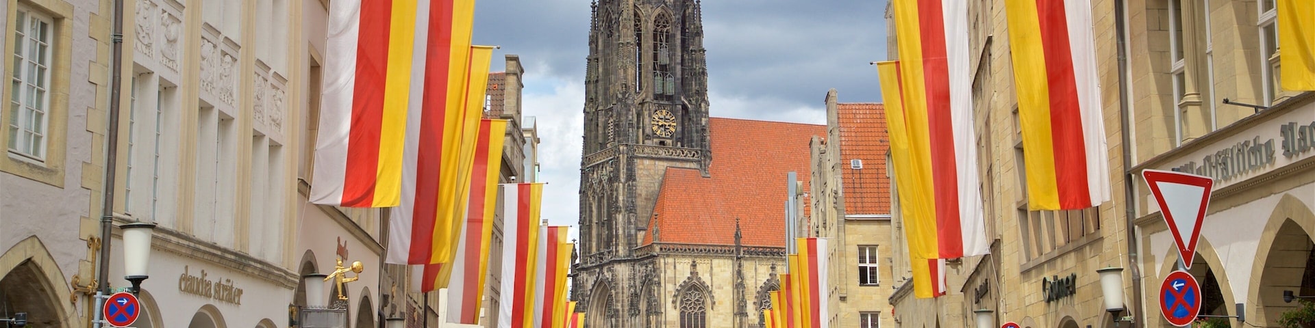 Eine belebte Straße mit einer historischen Kirche und einem Bus im Hintergrund.