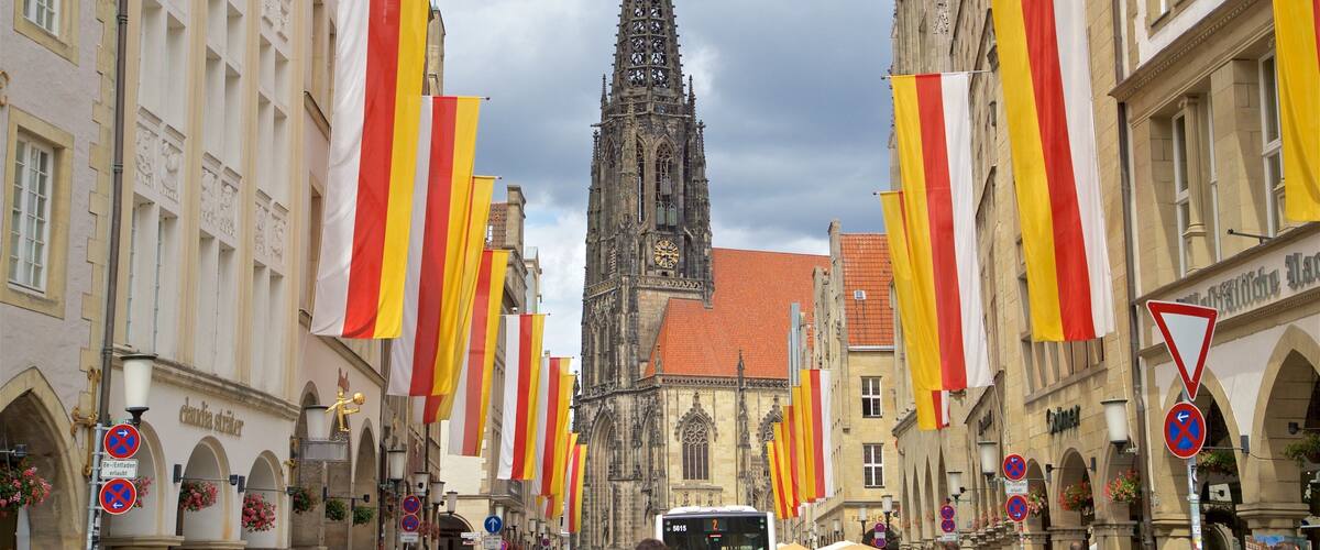 A crowded street with a historic church and a bus in the background.
