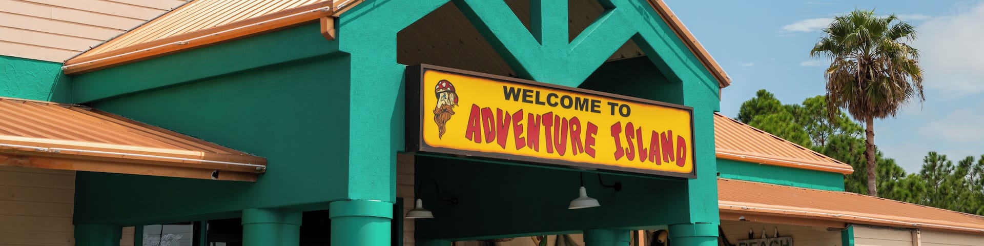 A building with a sign that reads "Arcade" and "Welcome to Adventure Island."