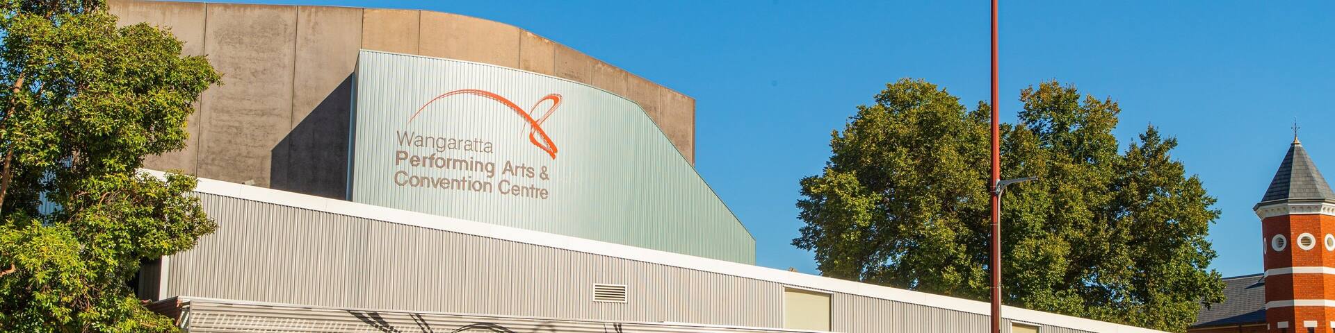 A building with a mural of a basketball hoop and a sign for the Wangaratta Performing Arts & Convention Centre.