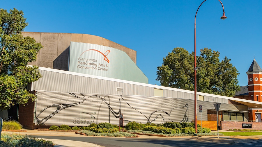 Un edificio con un mural de una canasta de baloncesto y un cartel del Centro de Artes Escénicas y Convenciones de Wangaratta.