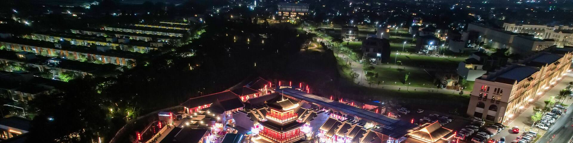 An aerial view of a traditional Chinese architectural complex at night, illuminated by street lights.