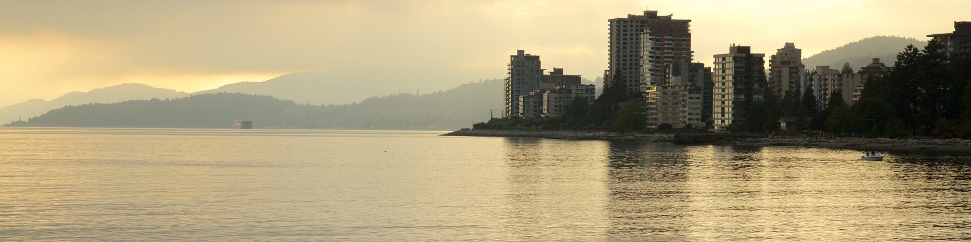 Ambleside Park mostrando um pôr do sol, paisagens litorâneas e uma cidade