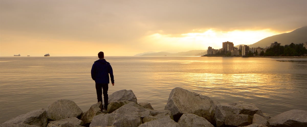 Ambleside Park featuring a sunset and a lake or waterhole as well as an individual male