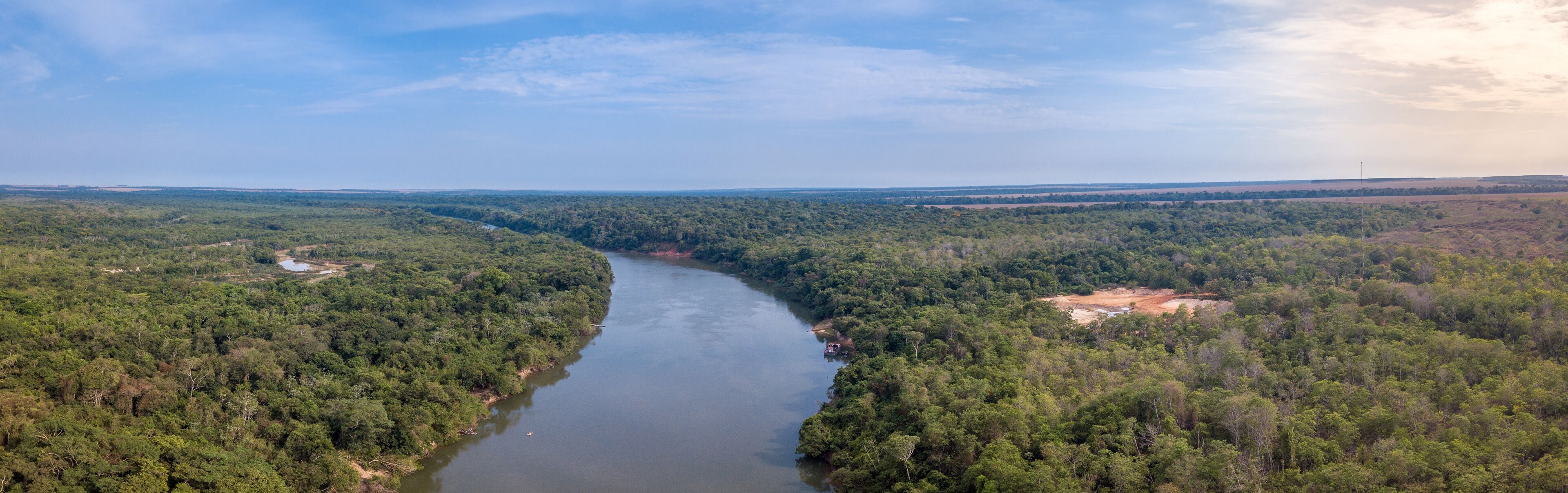 Beautiful panoramic aerial drone view of Rio Teles Pires and Amazon rainforest on sunny summer day with blue sky near Sinop city, Mato Grosso, Brazil. Concept of climate change and natural resources.