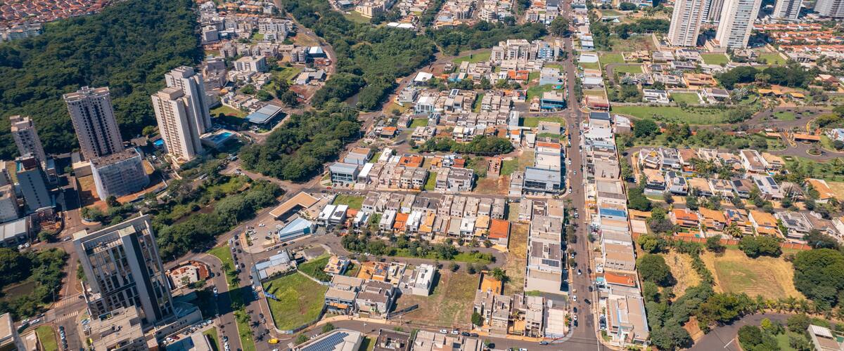 An aerial view of a city with dense urban development, including high-rise buildings, roads, and green spaces.