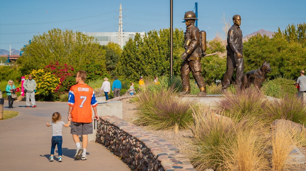 Tempe Beach Park showing a statue or sculpture and a garden as well as a family