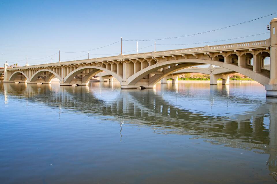 Eine große Steinbrücke über einem ruhigen Fluss.
