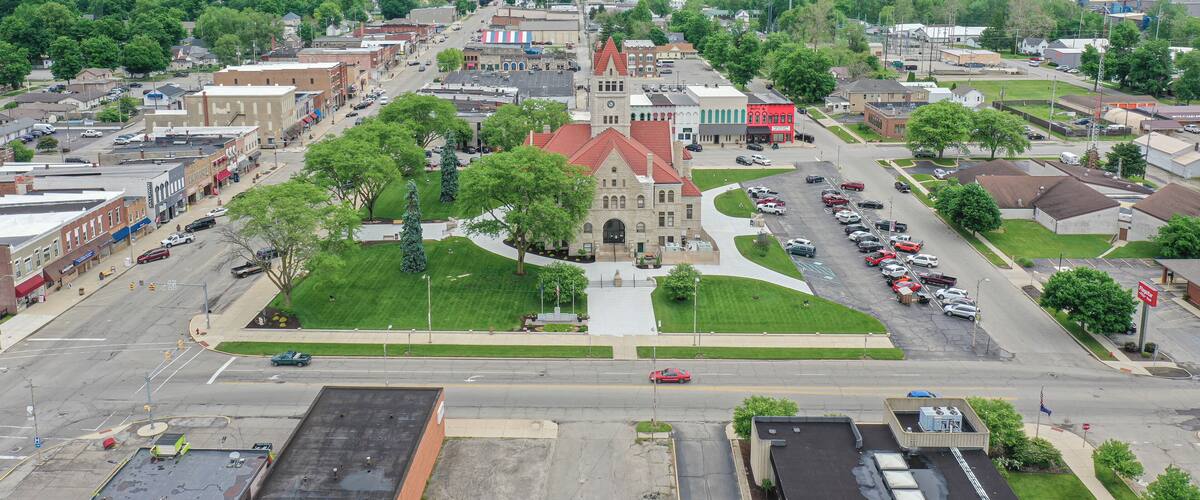 A town with a prominent church, a parking lot, and surrounding greenery.