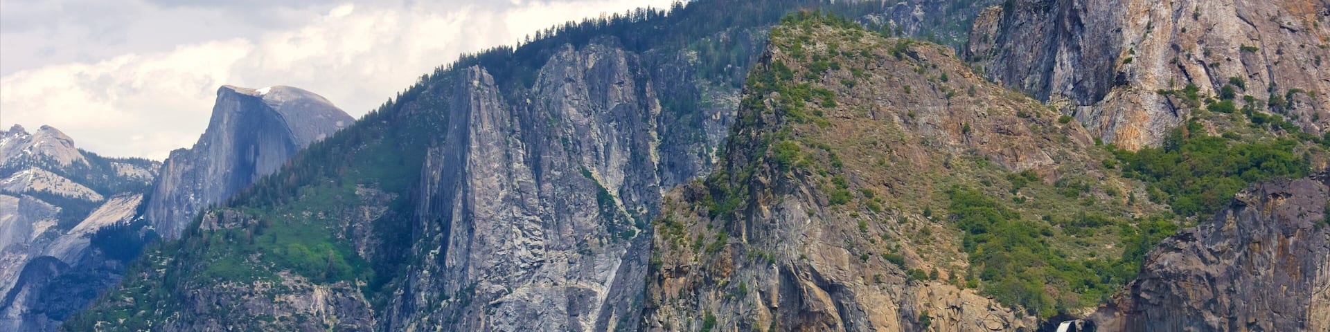 Tunnel View which includes mountains, a waterfall and forests