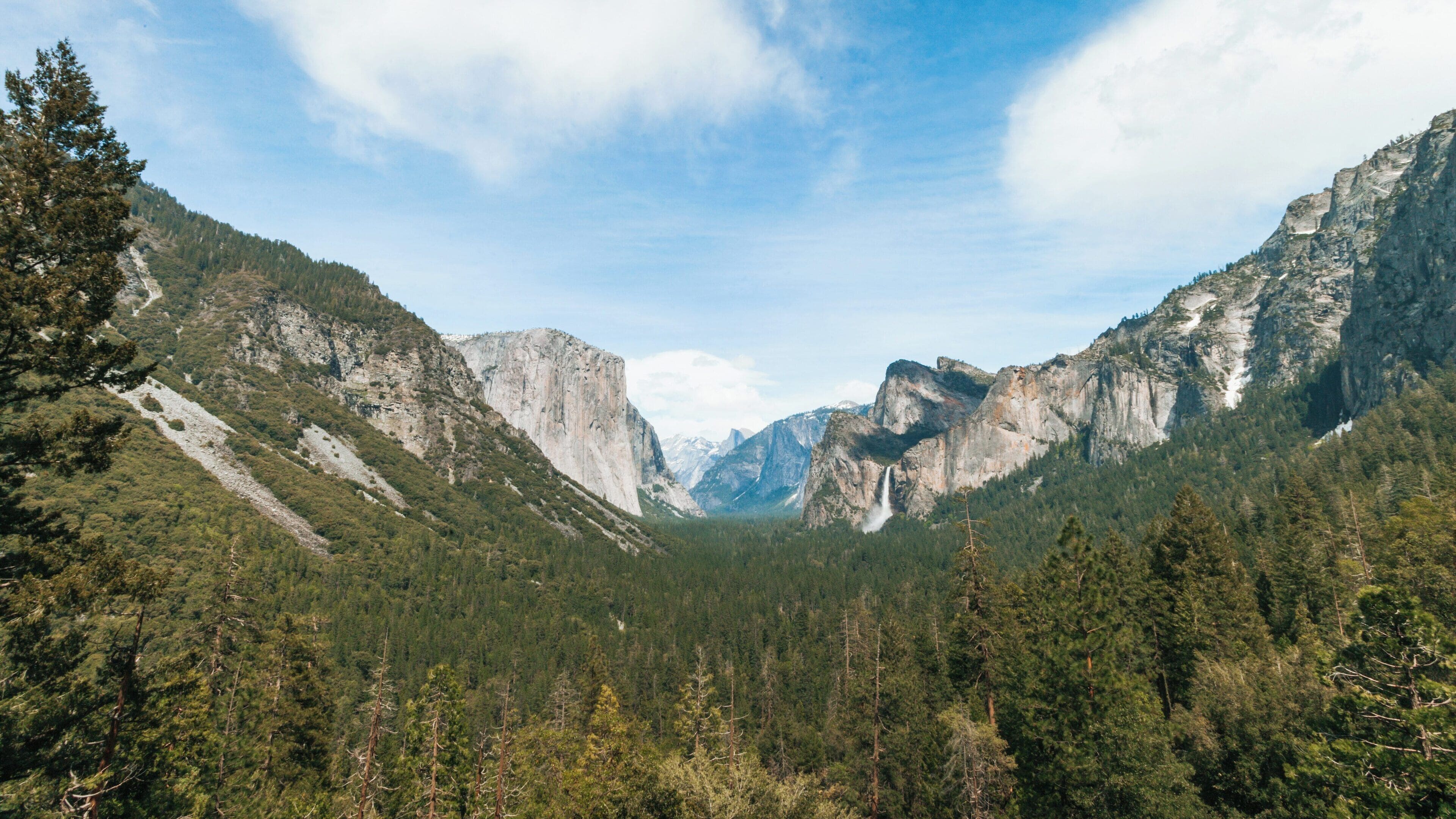 Majestic views of Tunnel View overlooking Yosemite Valley in Yosemite National Park showcasing towering cliffs and dense forests under a clear blue sky