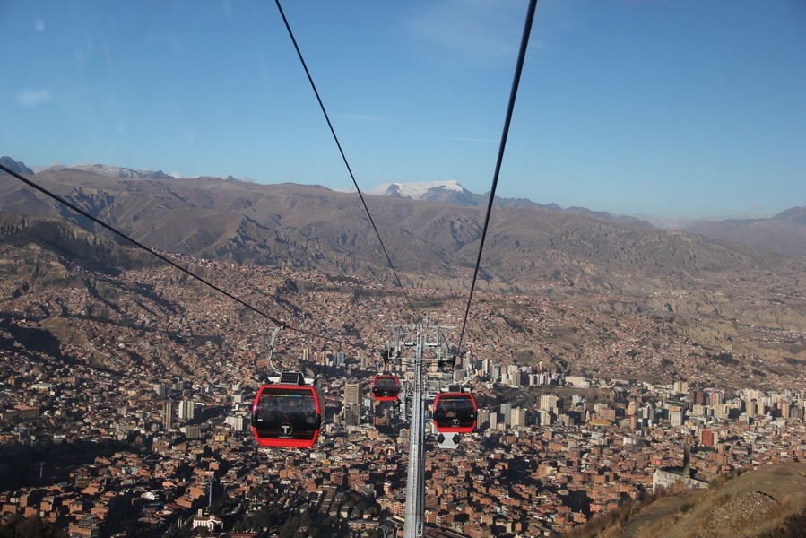 The cable car, opened on 30th May 2014, connects La Paz to the sprawling Metropolis of El Alto high above the city.  
Teleférico was inaugurated by Bolivia's current president, Evan Morales, in order to improve the commute to La Paz for residents of El Alto.  Although only 11 kilometres as the crow flies, by road this is a long, arduous journey which can take well over an hour.
Although built for the purpose of the city's commuters, it's also great news for visitors.  A ride on the cable car (which will set you back 3 bolivianos for a one-way ticket) affords some stunning views of La Paz, and can transport you up to El Alto in around 10 minutes.
El Alto is where the poorer residents of La Paz live, and for that reason it can be unsafe to wander around here without a guide (even with a guide, keep your valuables close to your chest).  Red Cap Walking Tours run an extended city tour, which incorporates El Alto, as well as other city attractions not covered on their standard free walking tour.