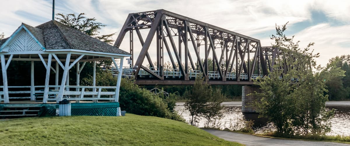 A bridge, a gazebo, and a body of water.