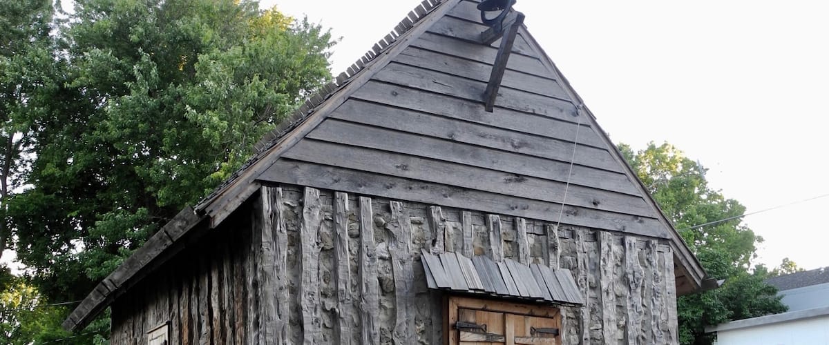 "The first St. Charles Borromeo Church, like this one, was constructed of vertical, hewn logs placed directly in the ground: an architectural style unique to the French in the New World during the 17th and 18th centuries. The church has been rebuilt on its original location. Jesse Francis, a local preservationist with 20 years experience restoring 18th French log buildings, directed the reconstruction. The work was done completely by with period tools in the manner of the 18th century. The church is part of an on-going historical interpretive program based on a re-creation of daily activities in this old French village."